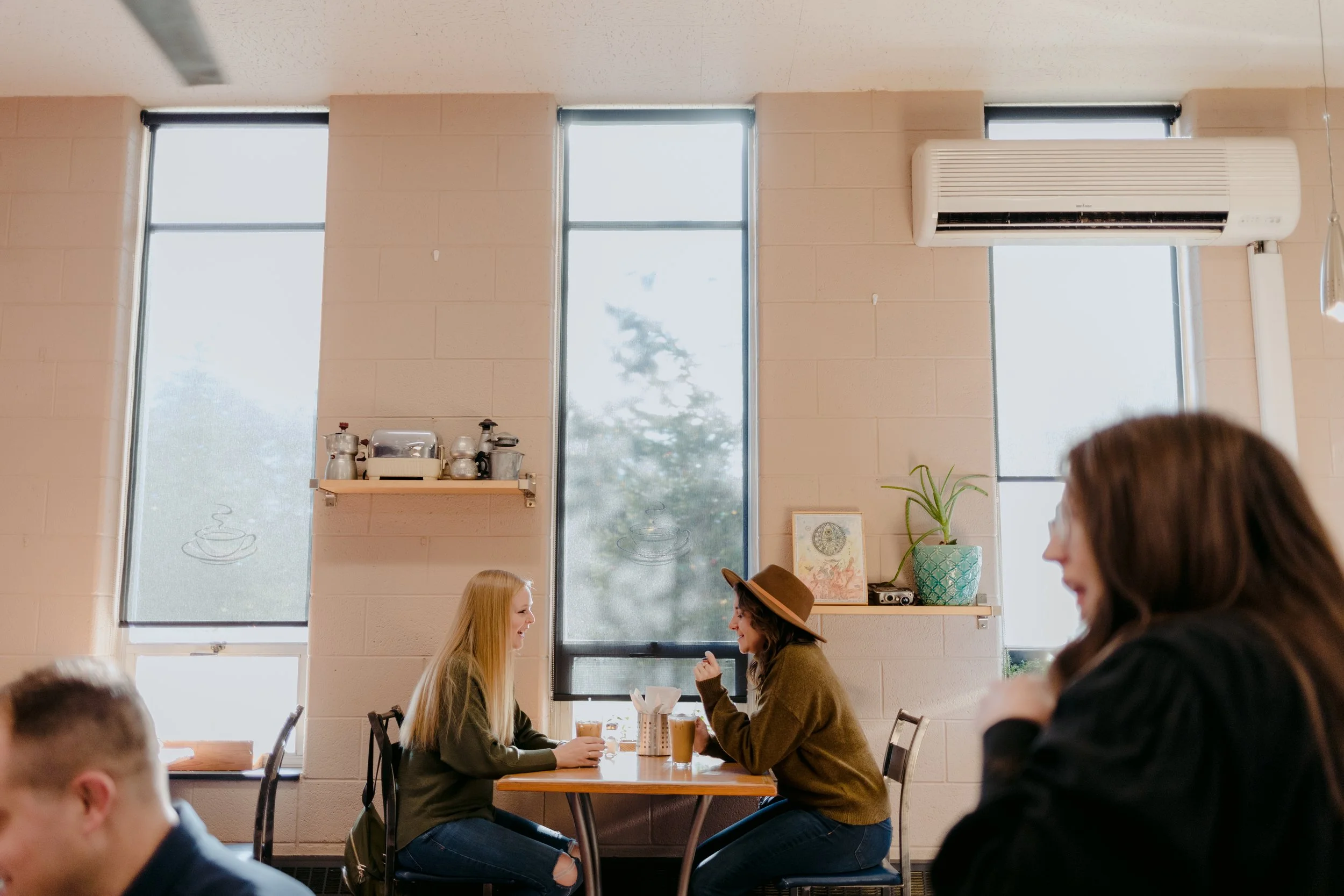 Inside Cuppa Joe's cafe with pale pink walls and tall windows