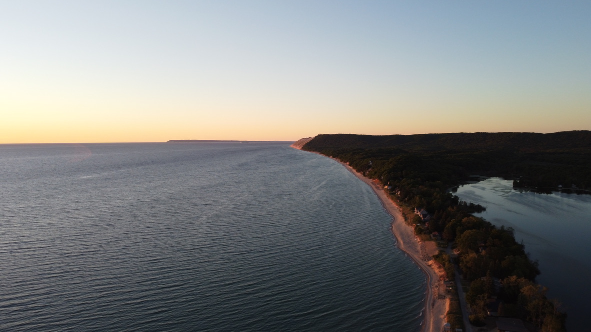 Dramatic red sand cliffs of Sleeping Bear Dunes rising from Lake Michigan at golden hour
