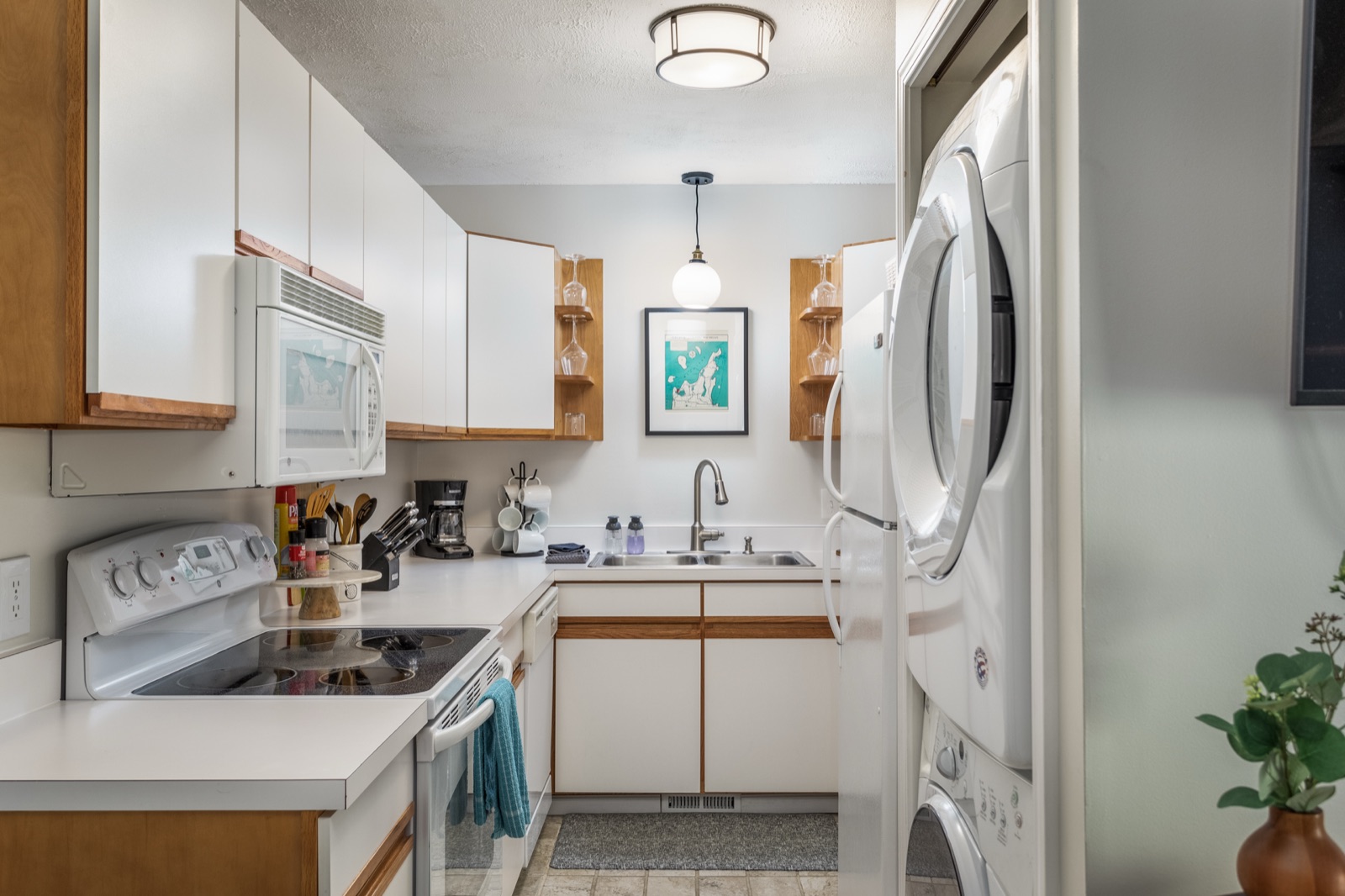 Full kitchen inside TART Trail Townhouse with white cabinetry and wood accents