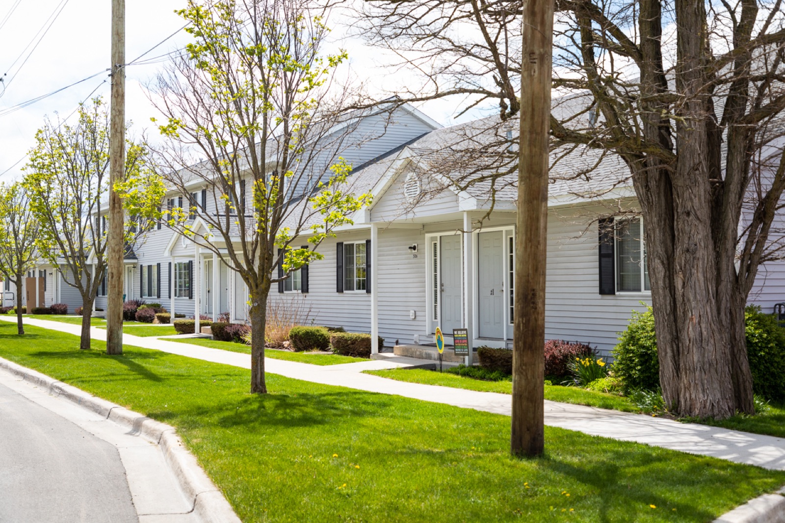 The row of Roost North townhouses on a tree-lined North Boardman street in spring